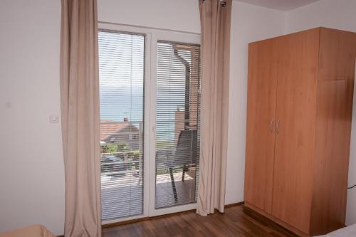 a bedroom with a large sliding glass door with a balcony at Apartments Ilija in Ohrid