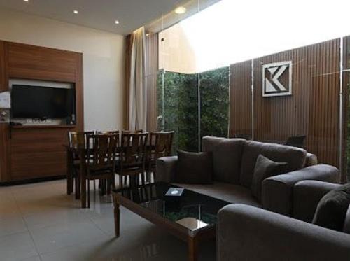 a living room with a couch and a dining room at Kayan Al Taif Hotel in Taif