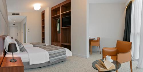 a bedroom with a bed and a desk and a chair at Priska Med Luxury Rooms in Split