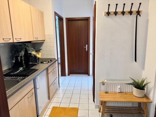 a kitchen with a table and a door to a hallway at StayTime - Linden Loft in Pulsnitz