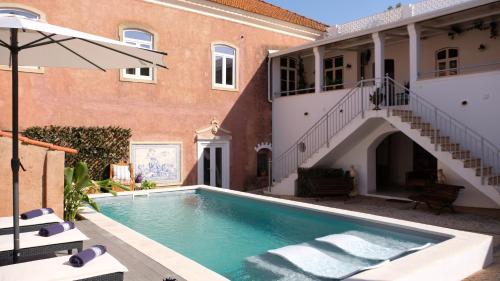 a swimming pool in the courtyard of a house at Casa das Amendoeiras in Silves