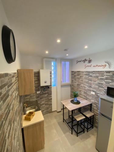 a kitchen with a sink and a table in a room at BERNOCCHI ROMA APARTMENT, difronte metropolitana in Acilia