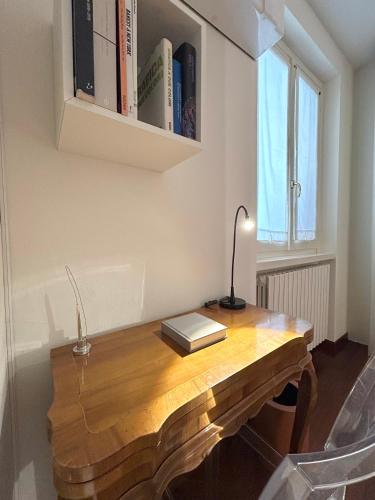 a wooden table with a lamp and books on it at COMO mi CASA in Malgrate