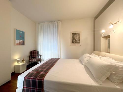 a bedroom with a large white bed and a window at COMO mi CASA in Malgrate