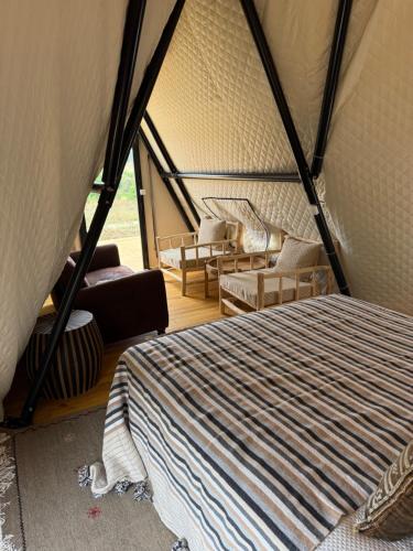 a room with a bed and chairs in a tent at Luxury Bedouin Tent in Aljezur