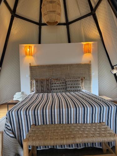 a bed in a tent with a bench next to it at Luxury Bedouin Tent in Aljezur