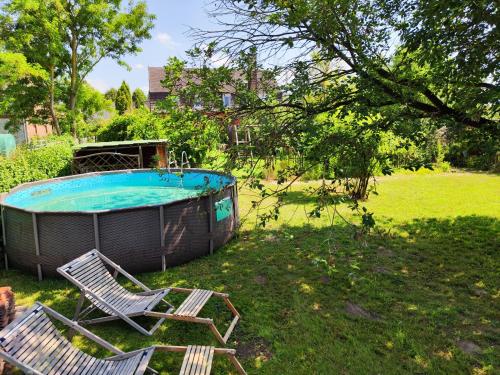 two chairs and a swimming pool in a yard at Großzügige Ferienwohnung nahe Berlin in Nauen