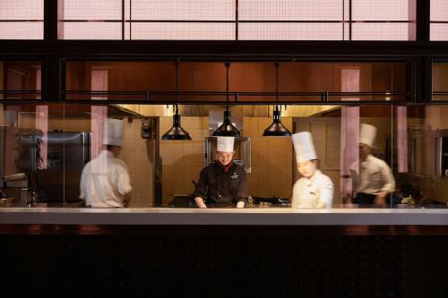 a group of chefs working in a kitchen at Sheraton Hanoi Hotel in Hanoi