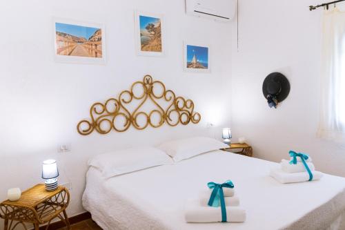 a bedroom with a white bed with two white boxes at Villa Stella, with garden, five minutes from the beach in Torre delle Stelle