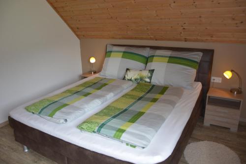 ein großes Bett in einem Zimmer mit Holzdecke in der Unterkunft Bio- u. Gesundheitsbauernhof Offenbacher in Seckau