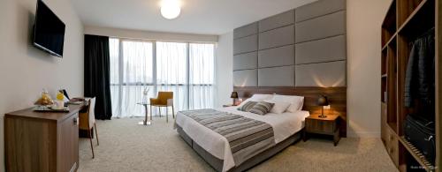 a bedroom with a bed and a desk and a television at Priska Med Luxury Rooms in Split
