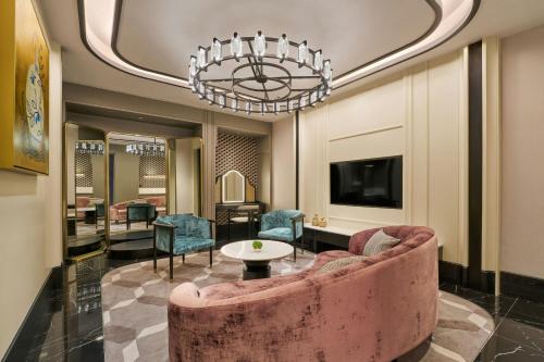 a living room with a pink couch and a chandelier at The Millen Penang, Autograph Collection in George Town