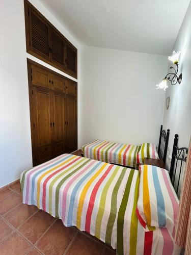 two beds sitting next to each other in a bedroom at Chalet con piscina privada grupos in Conil de la Frontera