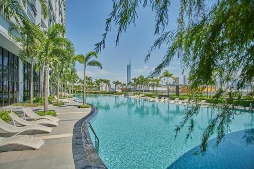a swimming pool with chairs and palm trees next to a building at Eco Residence By CNN in Kuala Lumpur