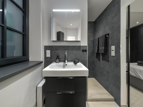 a bathroom with a white sink and a bed at Luxury Design Loft in Hamburg