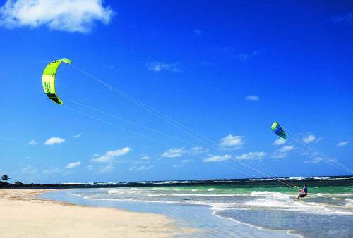 a man is flying a kite on the beach at Villa Teale Serene Dorado Escape in Dorado