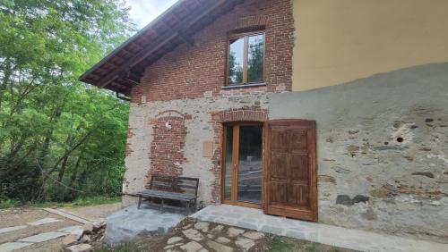 a brick building with a wooden door and a bench at Casamapun 