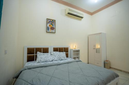 a bedroom with a large bed in a white room at Baith Al Jannah in Abu Dhabi