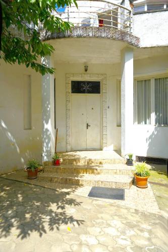 a front door of a house with stairs and plants at Pospolita Guest House in Kutaisi