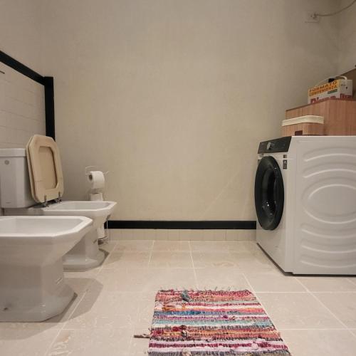 a bathroom with a washing machine and a toilet at Pelikan Lake House in Shkodër