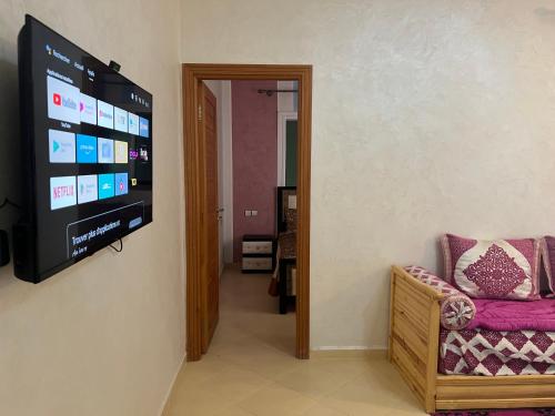 un salon avec une télévision à écran plat sur un mur dans l'établissement Appartement, à Martil