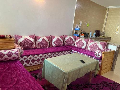 - un salon avec un canapé violet et une table dans l'établissement Appartement, à Martil