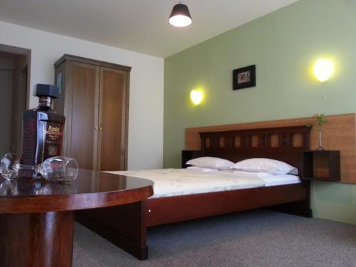 a bedroom with a bed and a table with a bottle of alcohol at Sea View Family Hotel in Kranevo