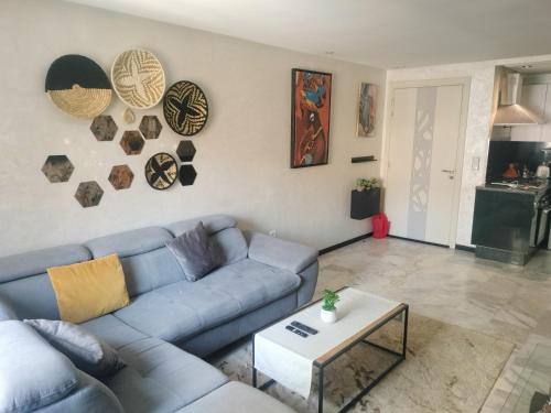 a living room with a blue couch and a table at Studio Centre Ville in Marrakech