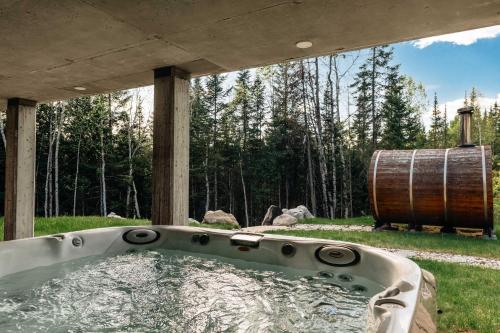 a bath tub with a barrel in a yard at Le Vertige - Ski Spa & Sauna in Saint Come