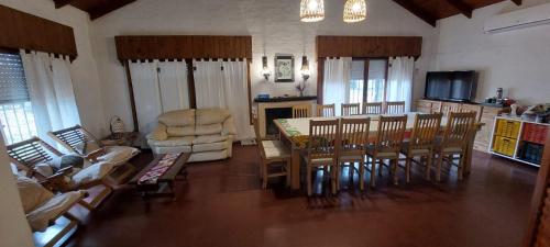a living room with a table and chairs and a kitchen at LA ARAUCARIA, Casa de Campo in Trenque Lauquen