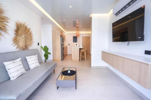 a living room with a couch and a coffee table at Macondo Quinta Avenida Residences in Playa del Carmen