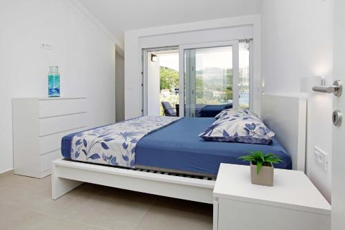 a bedroom with a bed with a blue comforter at MaMi in Korčula