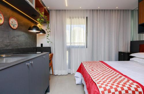 a bedroom with a bed and a sink and a kitchen at Atmosfera 360 - Metrô Brooklin, Berrini e Consulado Americano in Água Boa