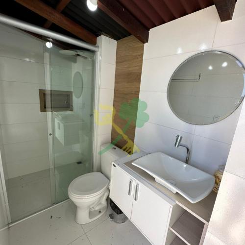 a bathroom with a toilet and a sink and a mirror at Duplex com Jacuzzi apt 315 Muriu Beach Village in Ceará-Mirim