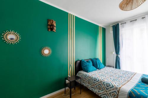 - une chambre verte avec un lit et un mur vert dans l'établissement le cocon du peyrou, à Montpellier