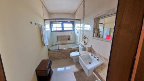 a bathroom with a sink and a toilet and a tub at Casa Centro de Guararema - Casa Bela Vista in Guararema
