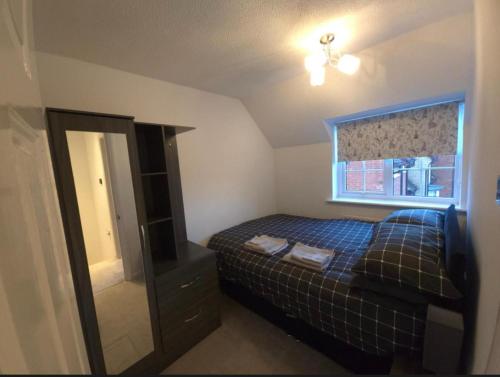 a small bedroom with a bed and a mirror at The Serenity Nook - 2 bed flat in the heart of Shefford with parking in Shefford