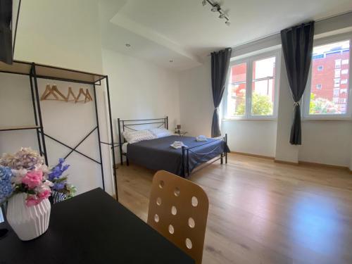 a room with a bed and a table with flowers on it at BERNOCCHI ROMA APARTMENT, difronte metropolitana in Acilia