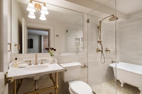 a bathroom with a sink and a toilet and a tub at 86 State Circle - Luxury Boutique Hotel in Annapolis