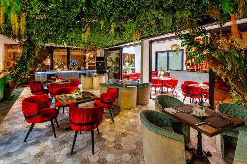 a restaurant with red chairs and tables and a bar at Ivy Garden Hotel Baku in Baku
