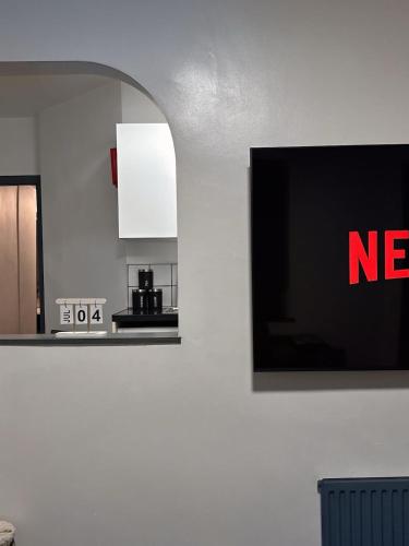 a tv hanging on a wall with aadobeadobeadobeadobeadobeadobe at 2 Bed Apartment off London Road in Sheffield