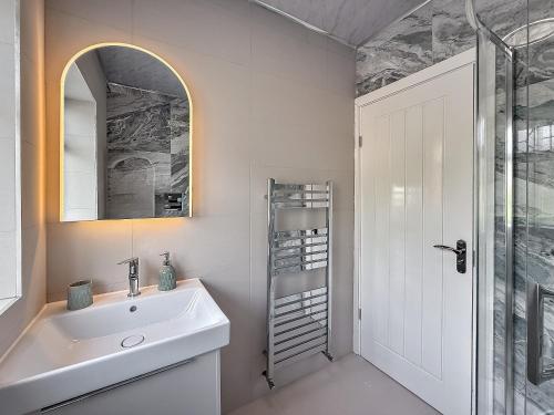 a white bathroom with a sink and a shower at LUTON LUXURY LIVING, Large PREMIUM House, Beautifully Landscaped PRIVATE GARDEN, Newly Refurbished Throughout, PARKING FOR 2 VEHICLES, Great Access to Central Luton & the M1 Motorway in Luton