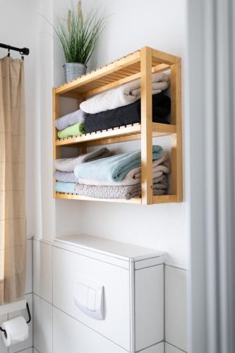 a bathroom with a rack of towels on a shelf at Landgut Seebühne Steigerwald - Guesthouse in Vestenbergsgreuth