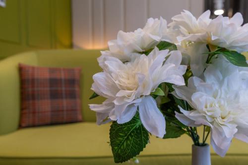 a vase filled with white flowers on a table at Ivy Garden Hotel Baku in Baku
