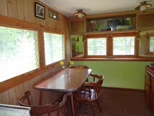 a dining room with a table and some windows at Pet-friendly, secluded, and peaceful pondside home near to Keene and Rindge NH in Fitzwilliam