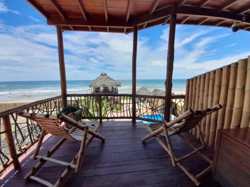 a porch with two chairs and the beach at Maria Jose Bungalows in Zorritos