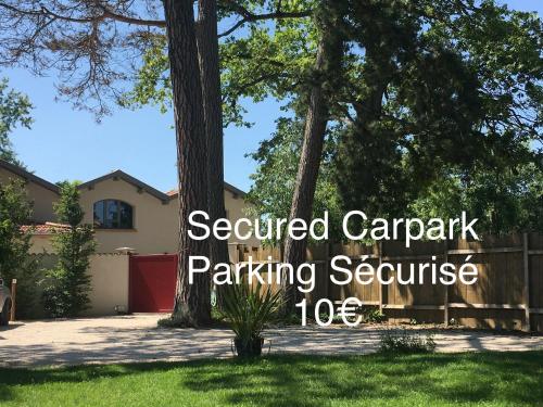 une cour avec une clôture et une maison avec les mots parking sécurisé service de stationnement dans l'établissement Aux Tourelles 1888 - Tres Proche Lyon #Clim #Piscine #Netflix #Parking Payant Securise, à Tassin-la-Demi-Lune