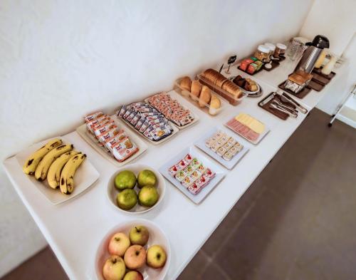 une table contenant de nombreux types de denrées alimentaires différents dans l'établissement Pousada Peruibe 455, à Peruíbe