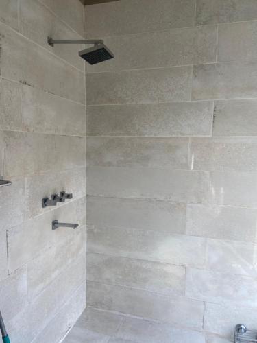a bathroom with a shower with a stone wall at Casa Cabalango in Cavalango
