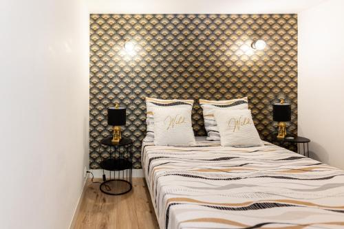 une chambre avec deux lits et deux lampes dans l'établissement Mirabeau Sous Les Toits - Tours, à Tours